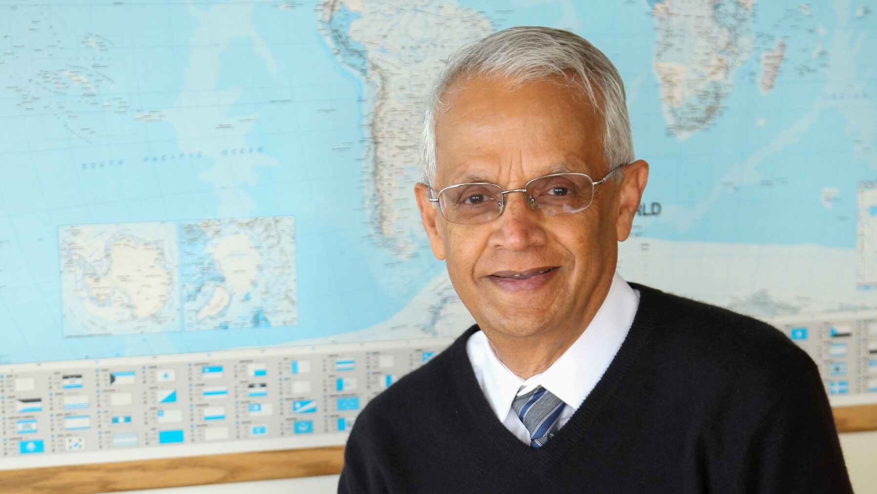 Ramanathan in front of world map.